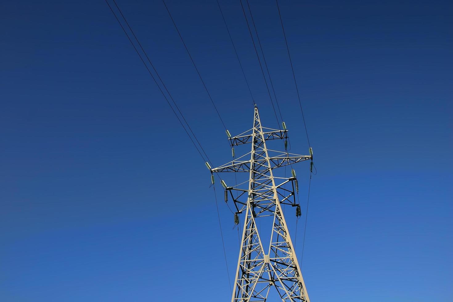 High power lines against clear blue sky photo