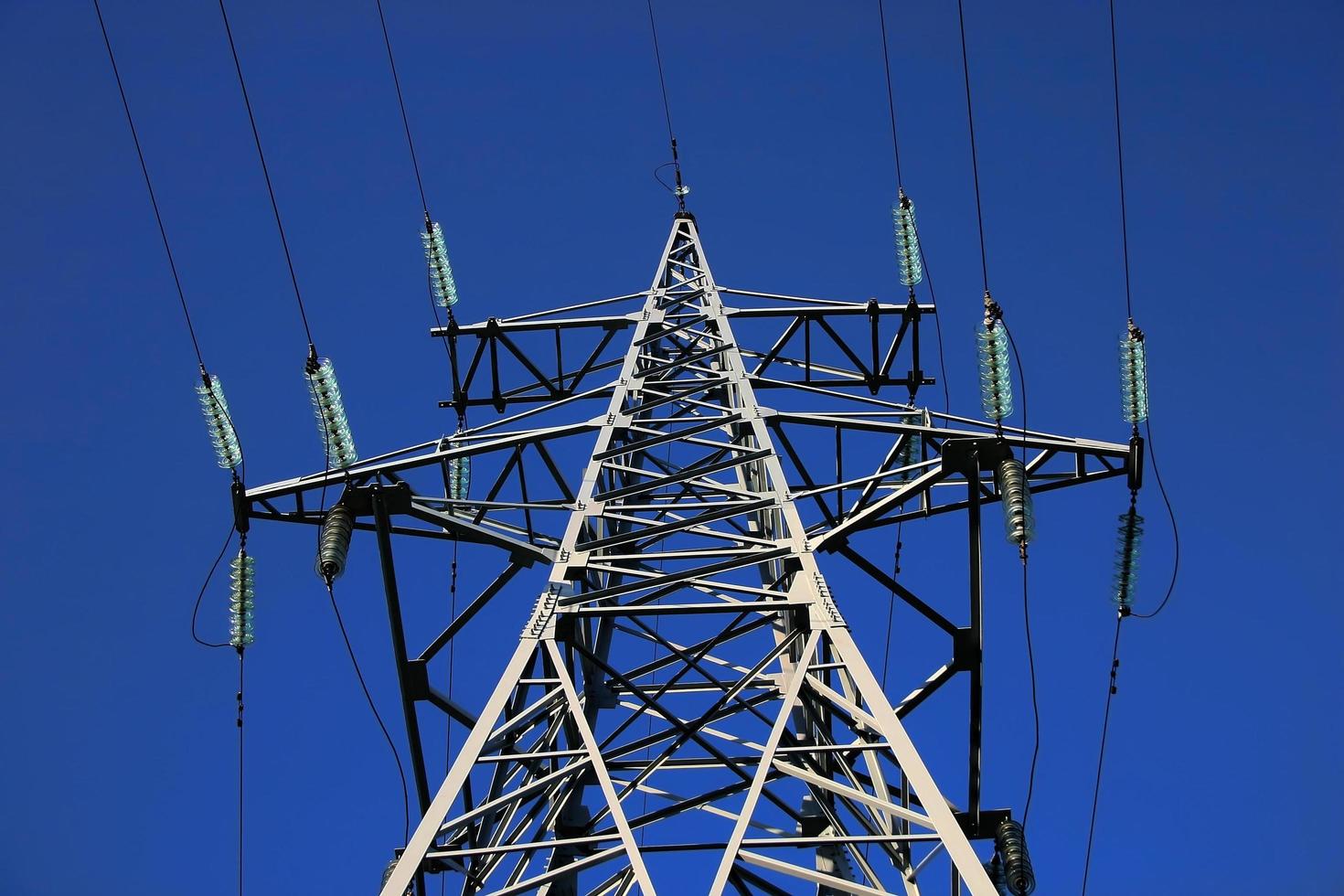 High power lines against clear blue sky photo