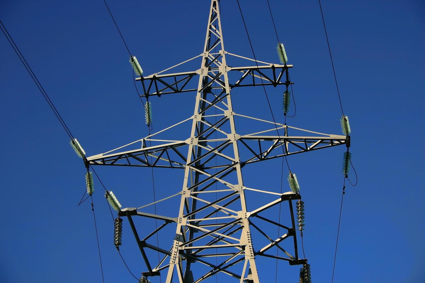 High power lines against clear blue sky photo