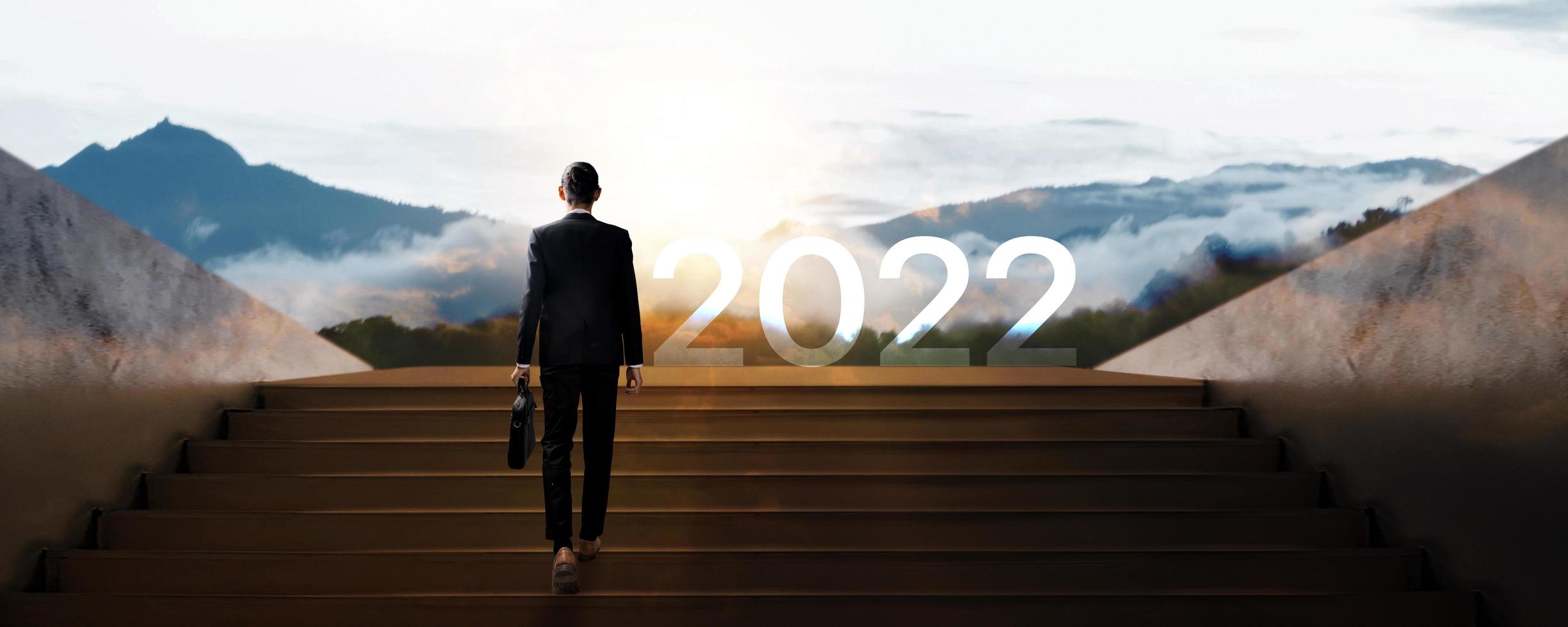 El hombre de negocios camina hacia el éxito en 2022, el liderazgo y el líder empresario confiado y confiado llevan la bolsa y suben la escalera para trabajar foto