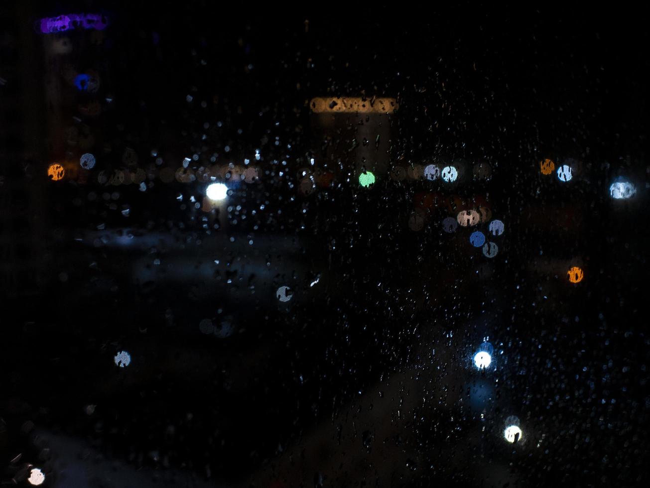 Rain drops on window with street bokeh lights photo