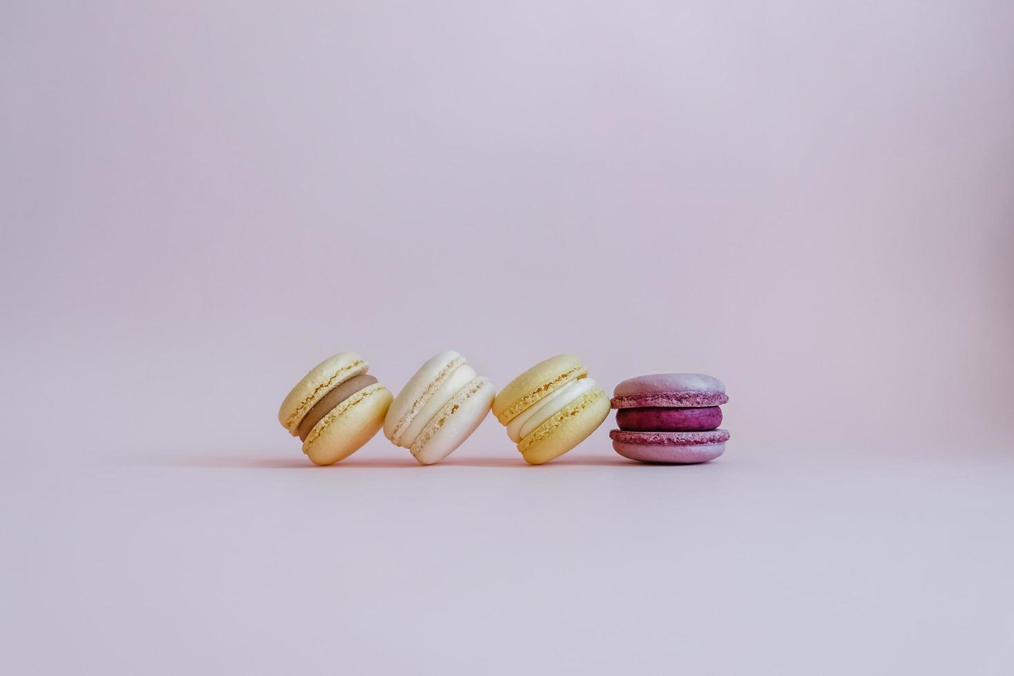 Color tasty macarons on the pink background. photo