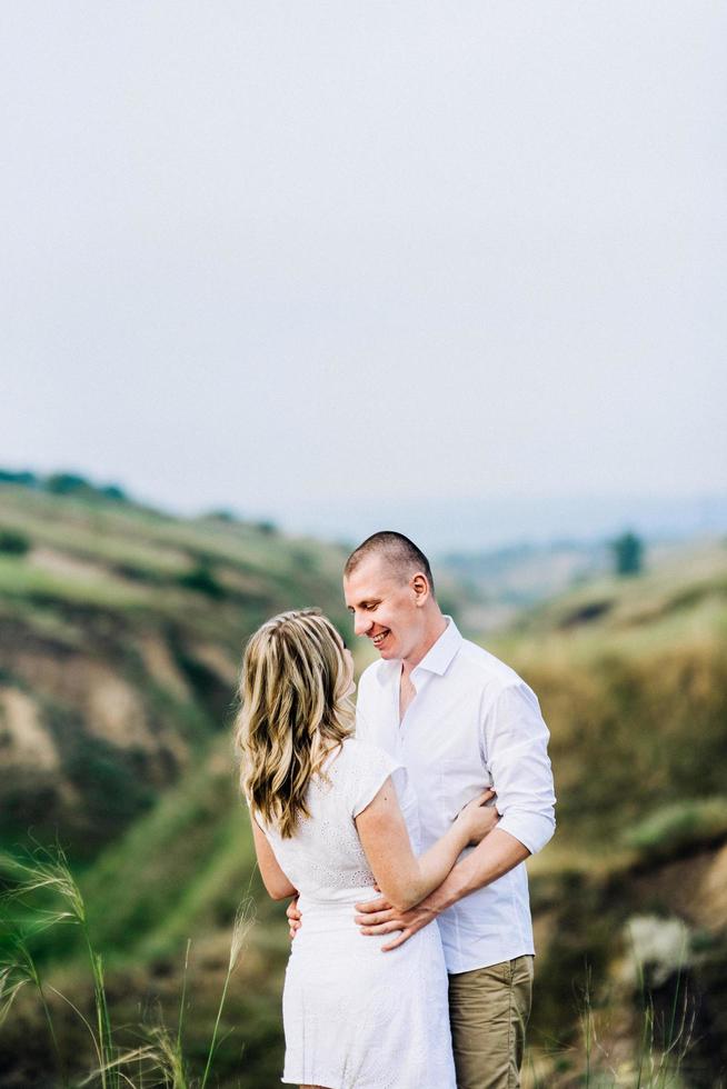 a guy with a girl in light clothes on the background of a green canyon photo