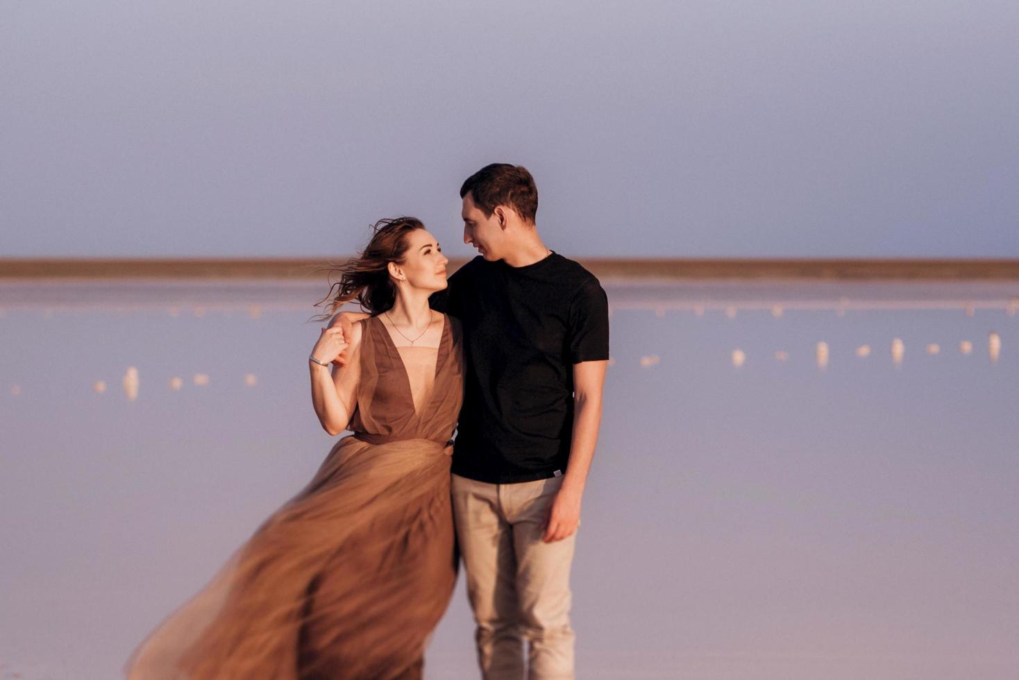 chica y chico en la orilla de un lago salado rosa foto