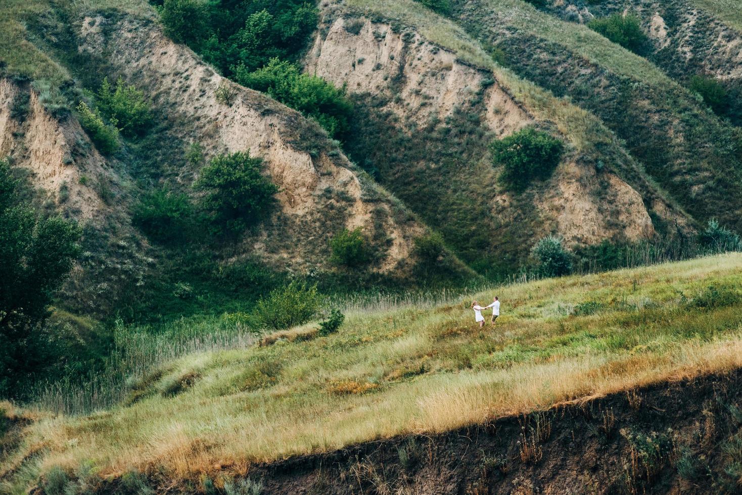 a guy with a girl in light clothes on the background of a green canyon photo