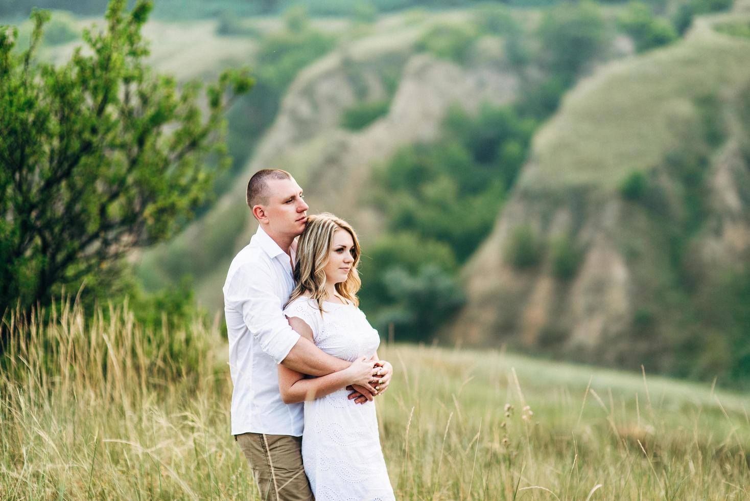 a guy with a girl in light clothes on the background of a green canyon photo