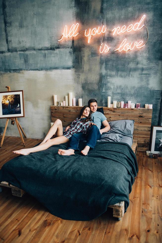 a guy and a girl lie on the bed in the room photo
