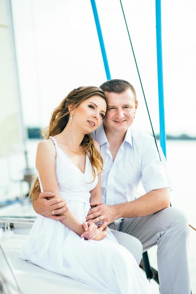 young couple guy and girl on a sailing yacht photo