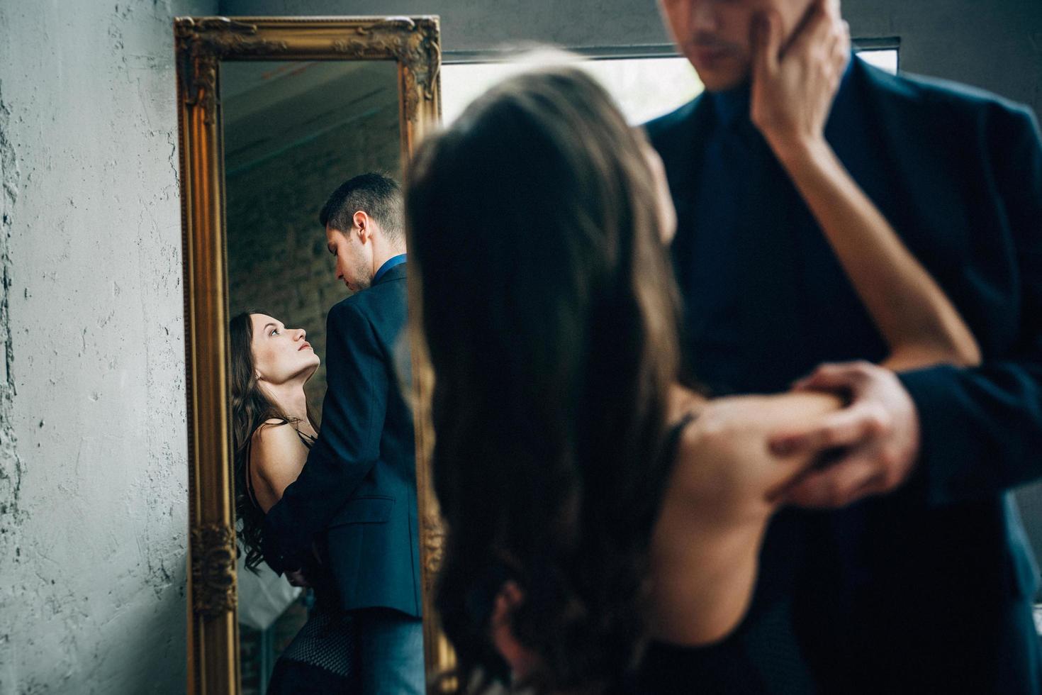 the girl reaches out to the guy and their images are reflected in the mirror photo