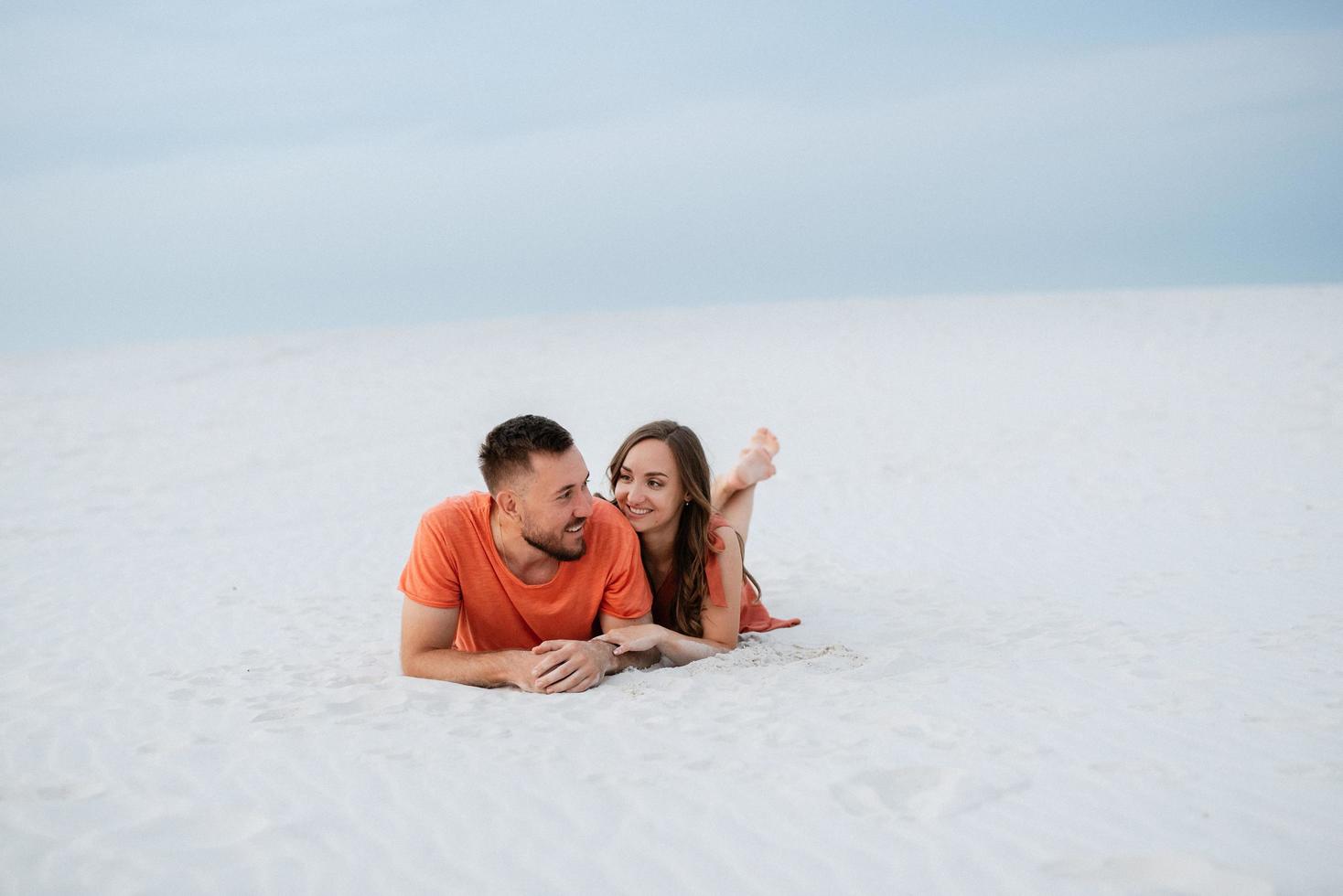 young couple in orange clothes with dog photo