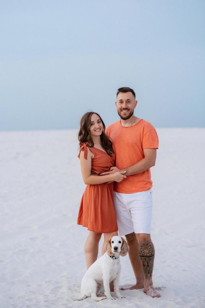 pareja joven, en, naranja, ropa, con, perro foto