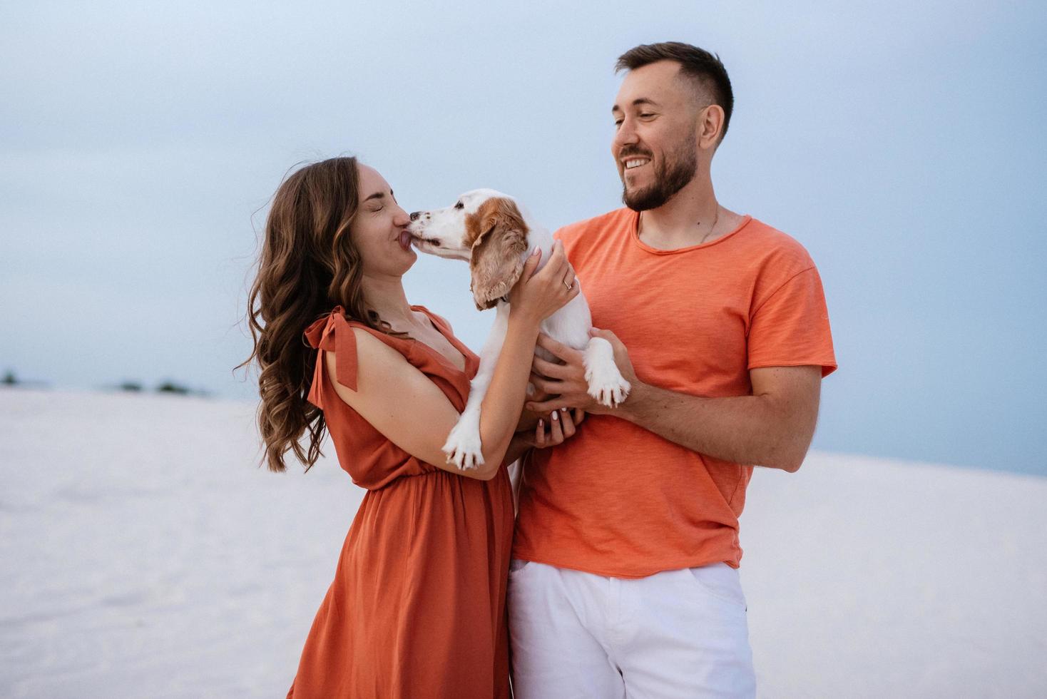 pareja joven, en, naranja, ropa, con, perro foto