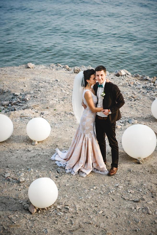 the groom in a brown suit and the bride in an ivory dress photo