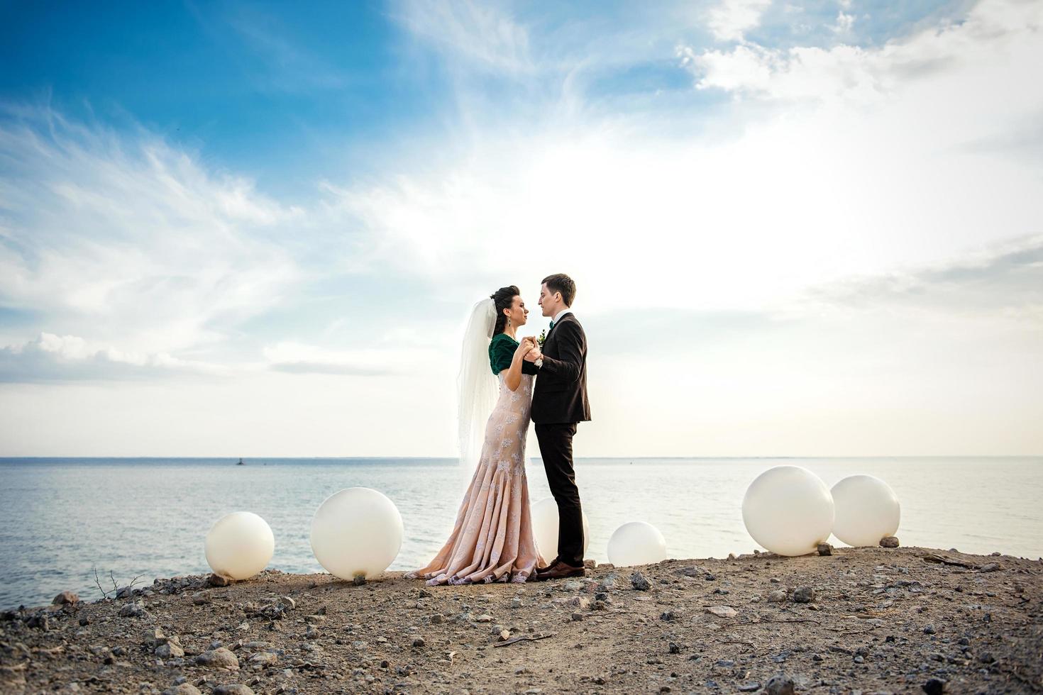 the groom in a brown suit and the bride in an ivory dress photo