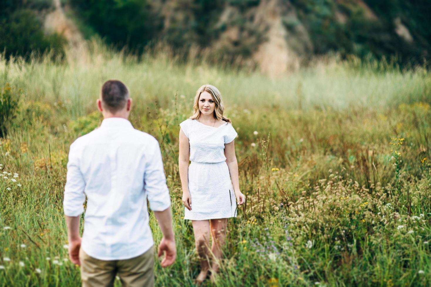 a guy with a girl in light clothes on the background of a green canyon photo