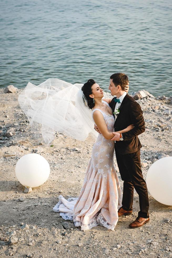 the groom in a brown suit and the bride in an ivory dress photo