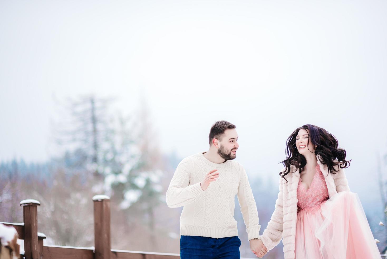 young couple on a walk in the snowy mountains photo