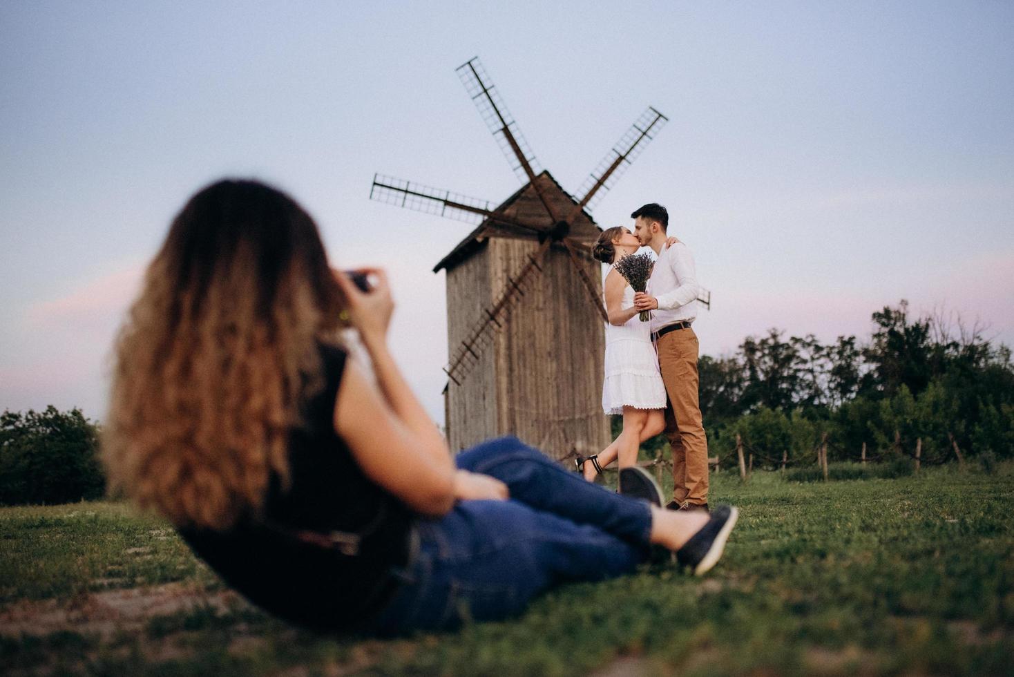 chica con un vestido blanco y un chico con una camisa blanca en un paseo al atardecer con un ramo foto