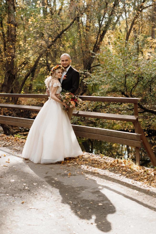 walk of the bride and groom through the autumn forest photo