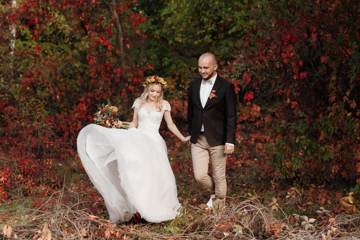 walk of the bride and groom through the autumn forest photo