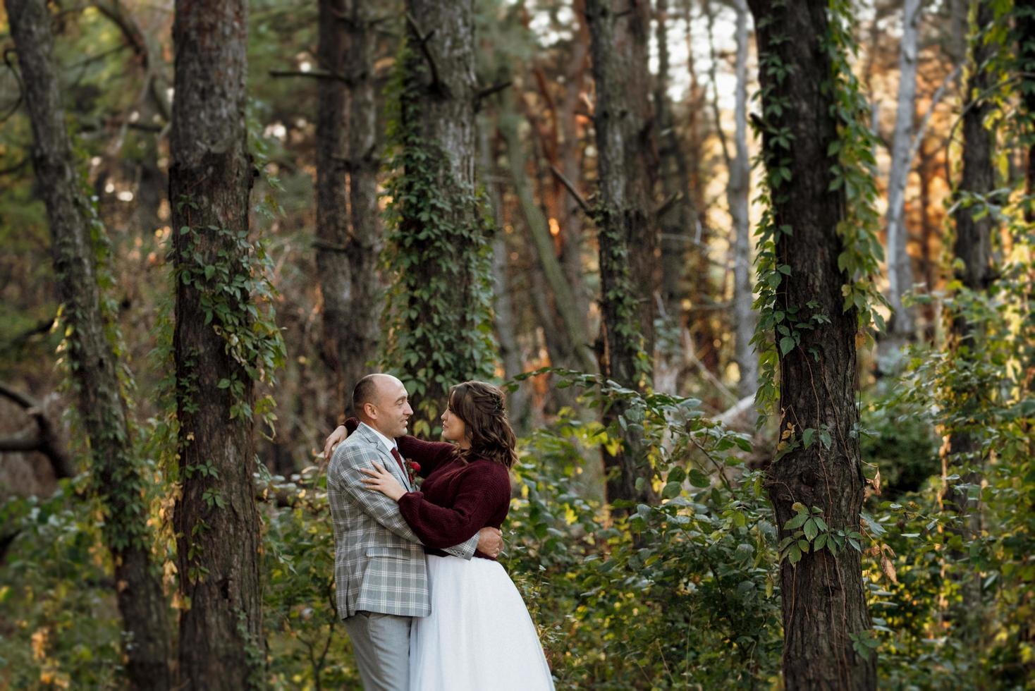 walk of the bride and groom through the autumn forest photo