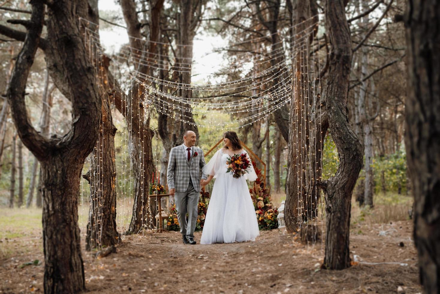 walk of the bride and groom through the autumn forest photo