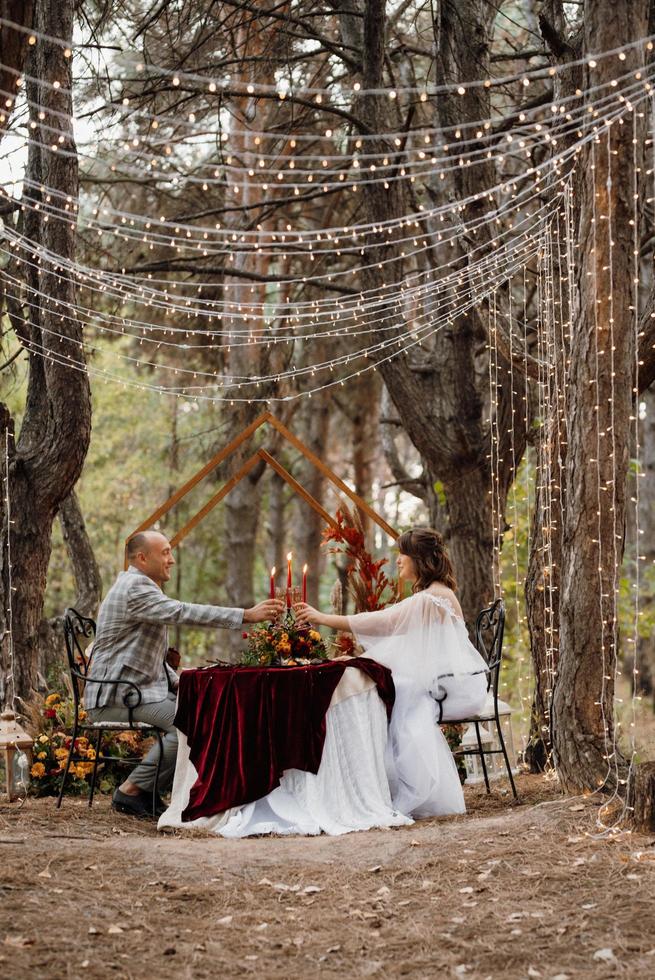 wedding dinner of a newlywed couple in the autumn forest photo