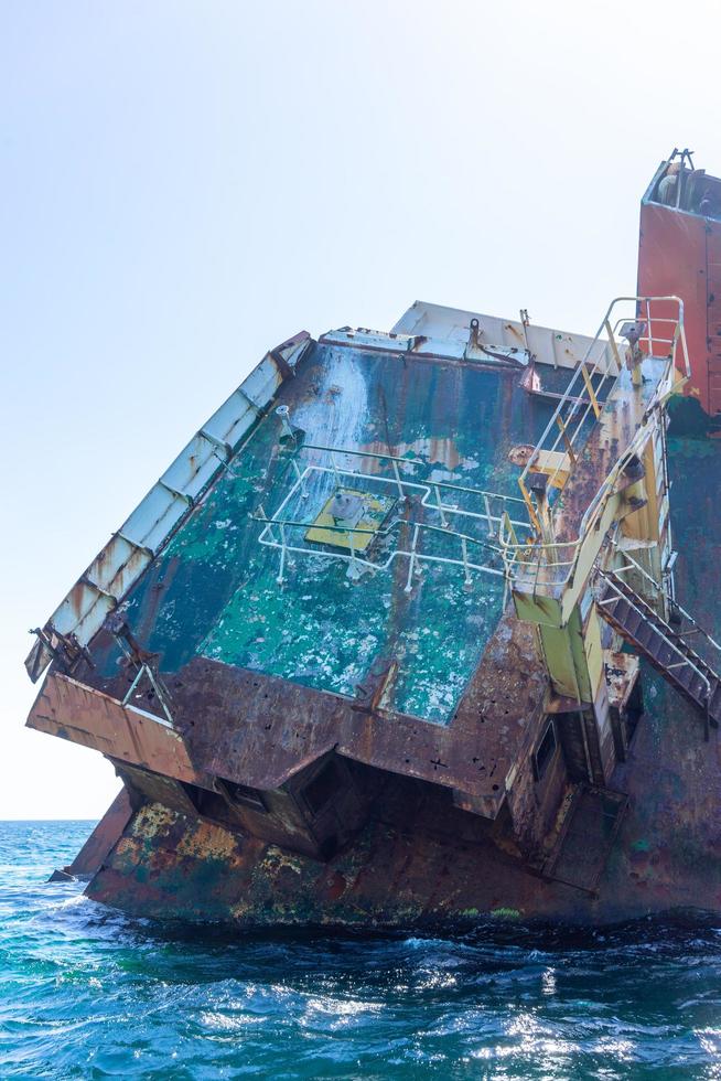 A sunken ship on the water surface of the sea. photo