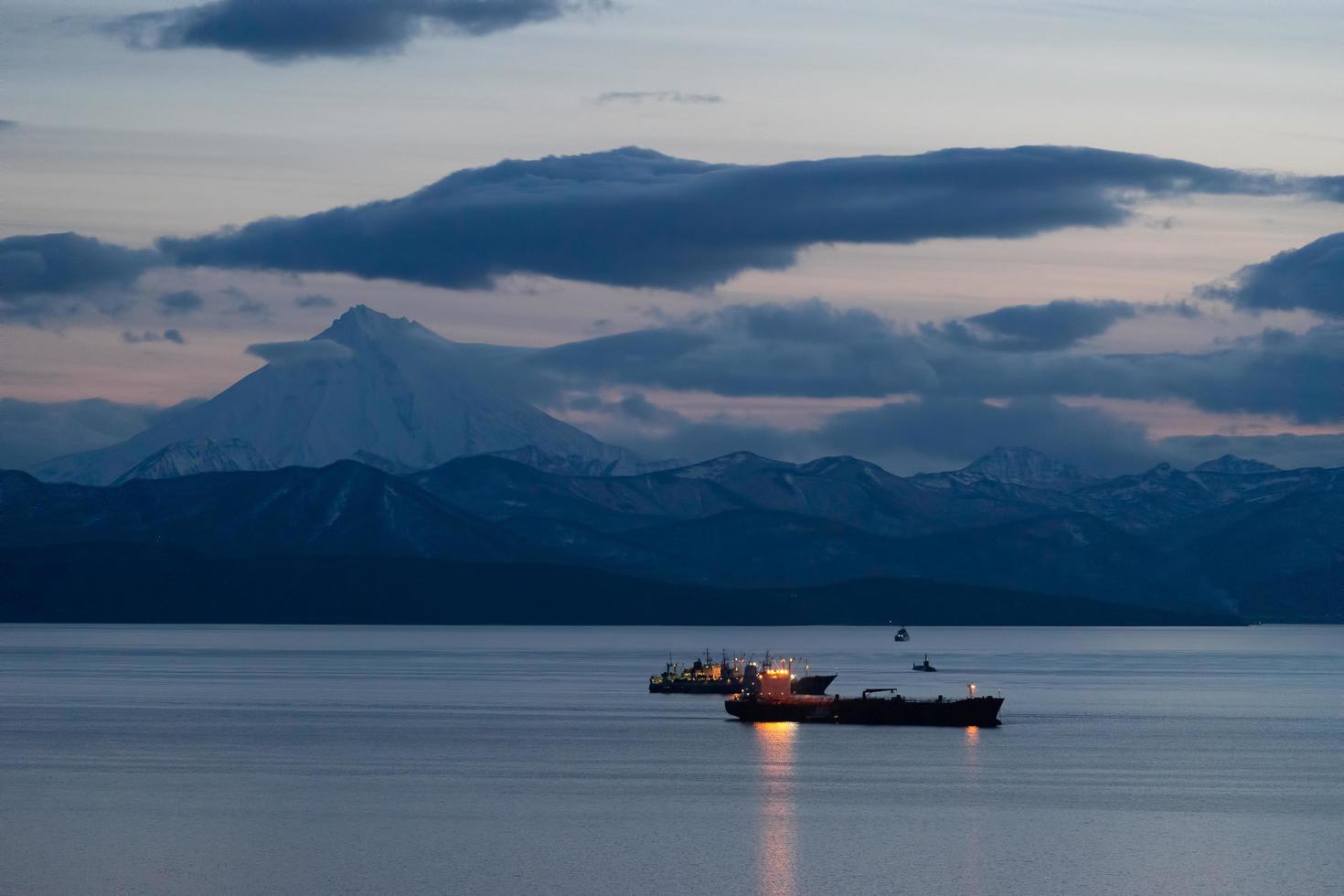 Ships in Avacha Bay on the background of a volcano. photo