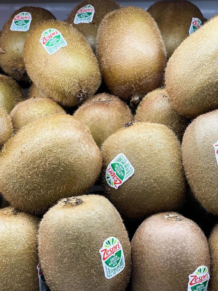 grupo de kiwi en el estante de la pantalla del supermercado. compras de comestibles de frutas. una pantalla para el fondo de la naturaleza. foto