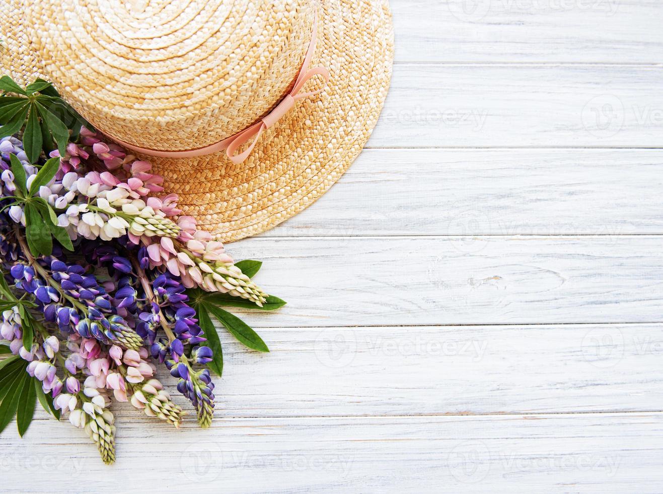 Straw hat and lupine flowers photo