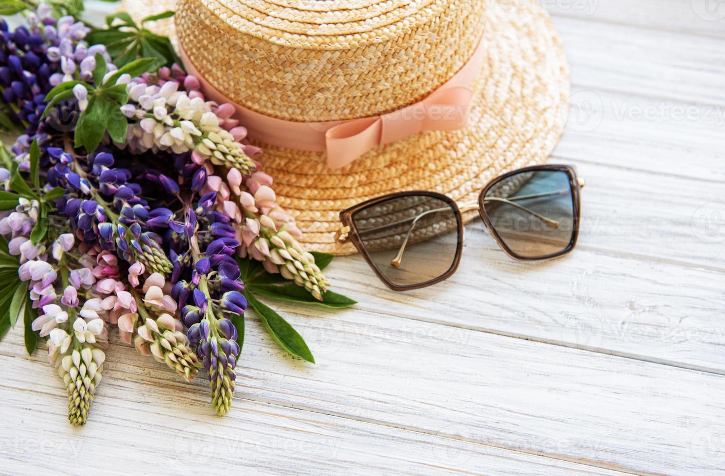 Straw hat and lupine flowers photo