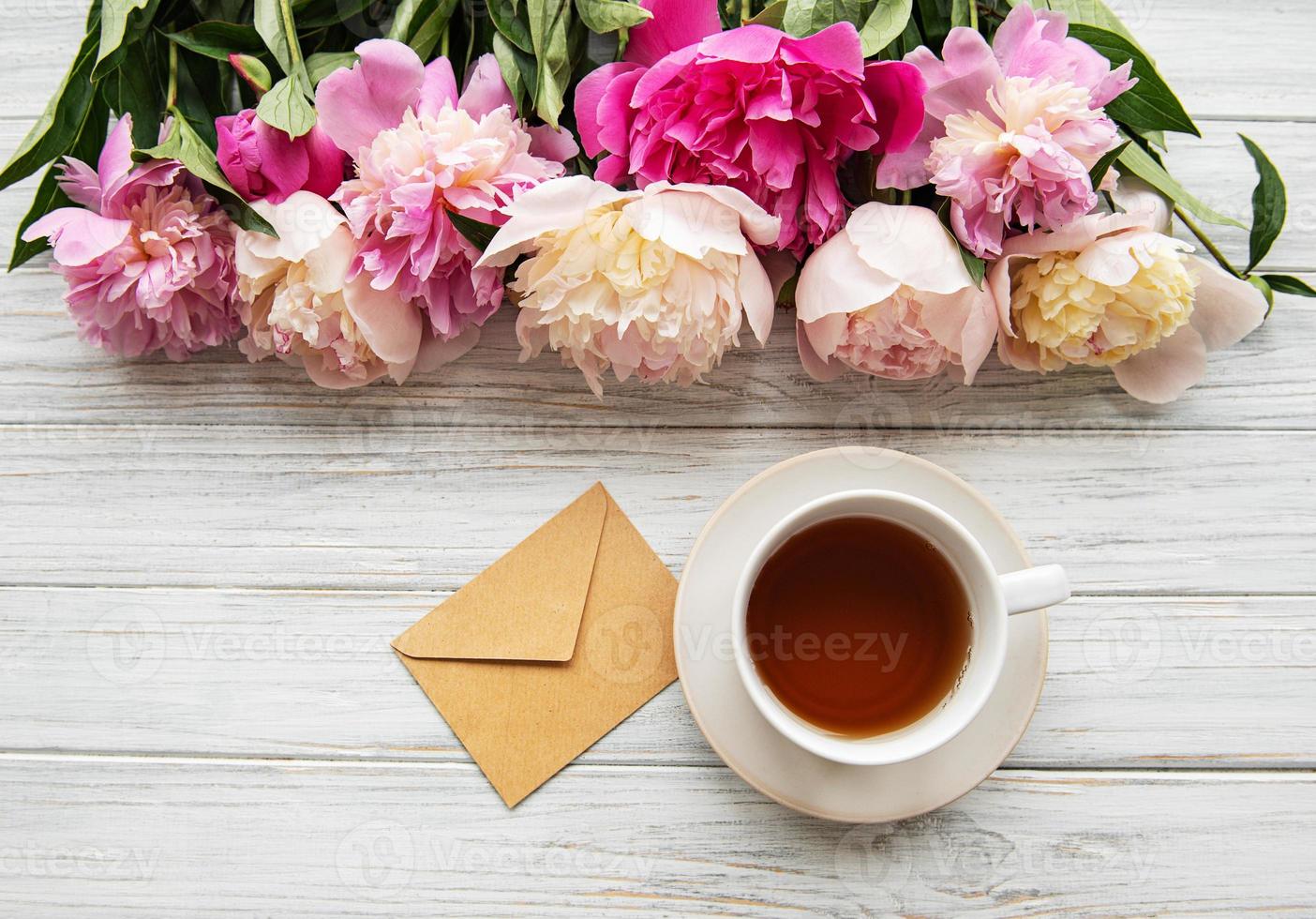 Cup of tea and pink peonies photo
