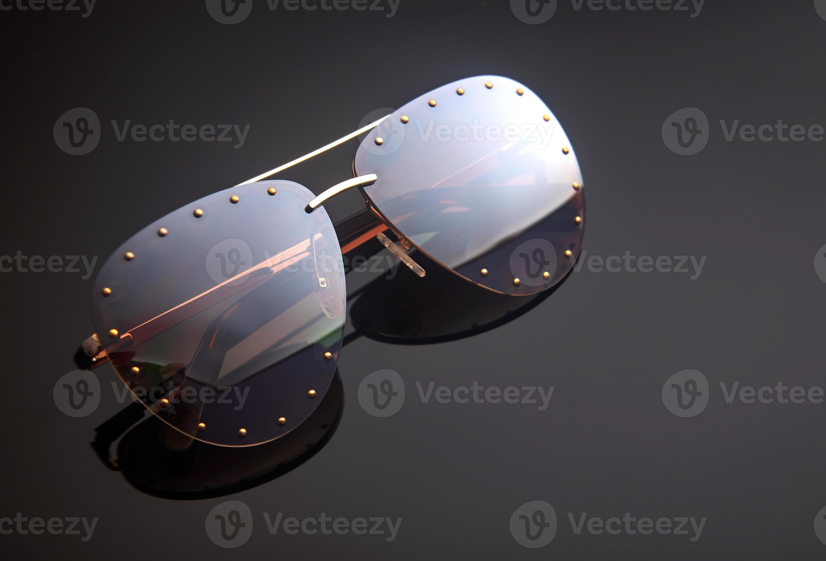Women’s sunglasses on a dark background with reflection. Place for text