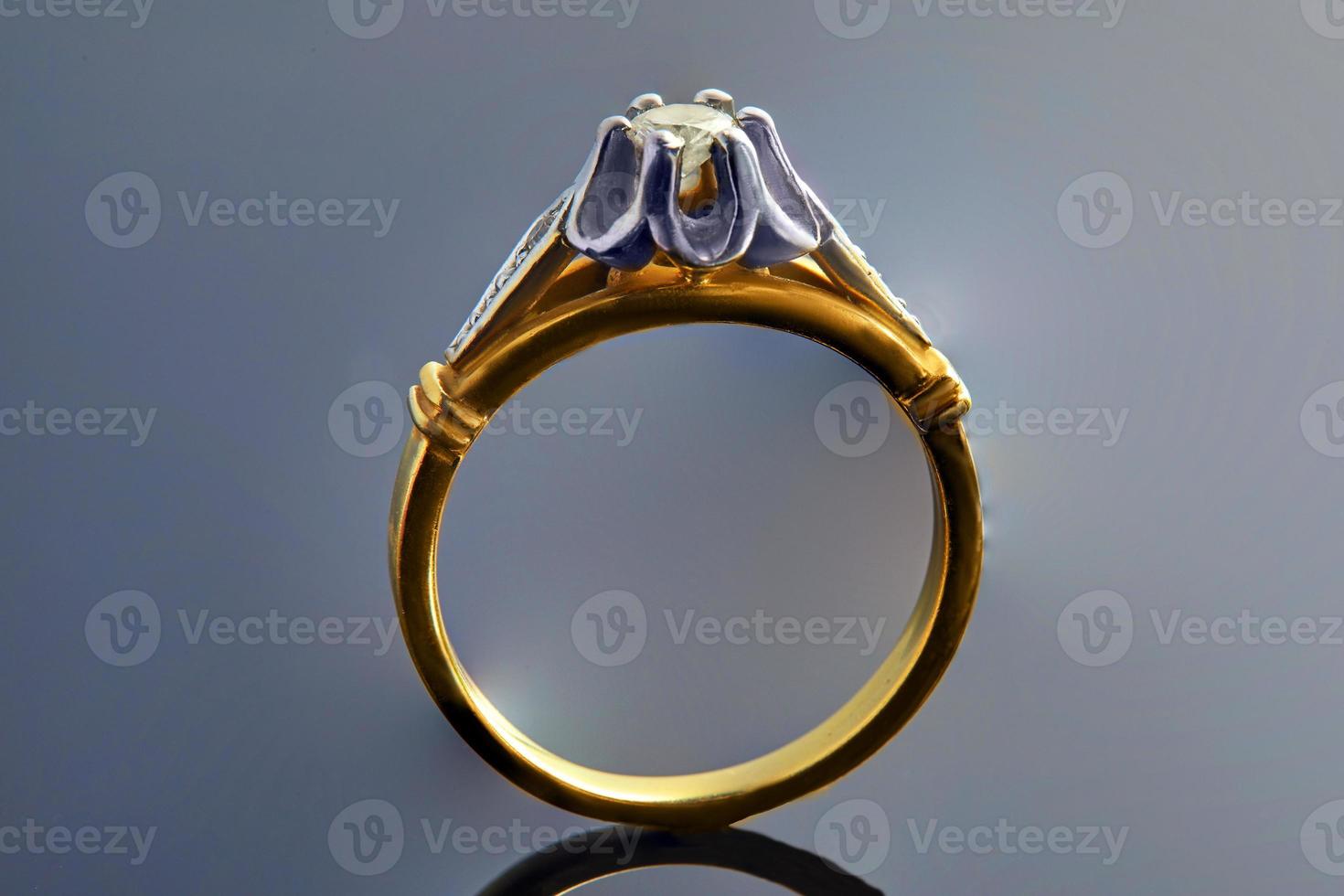 Gold ring in white and yellow gold with diamonds on a background with a gradient and reflection. Jewelry production photo
