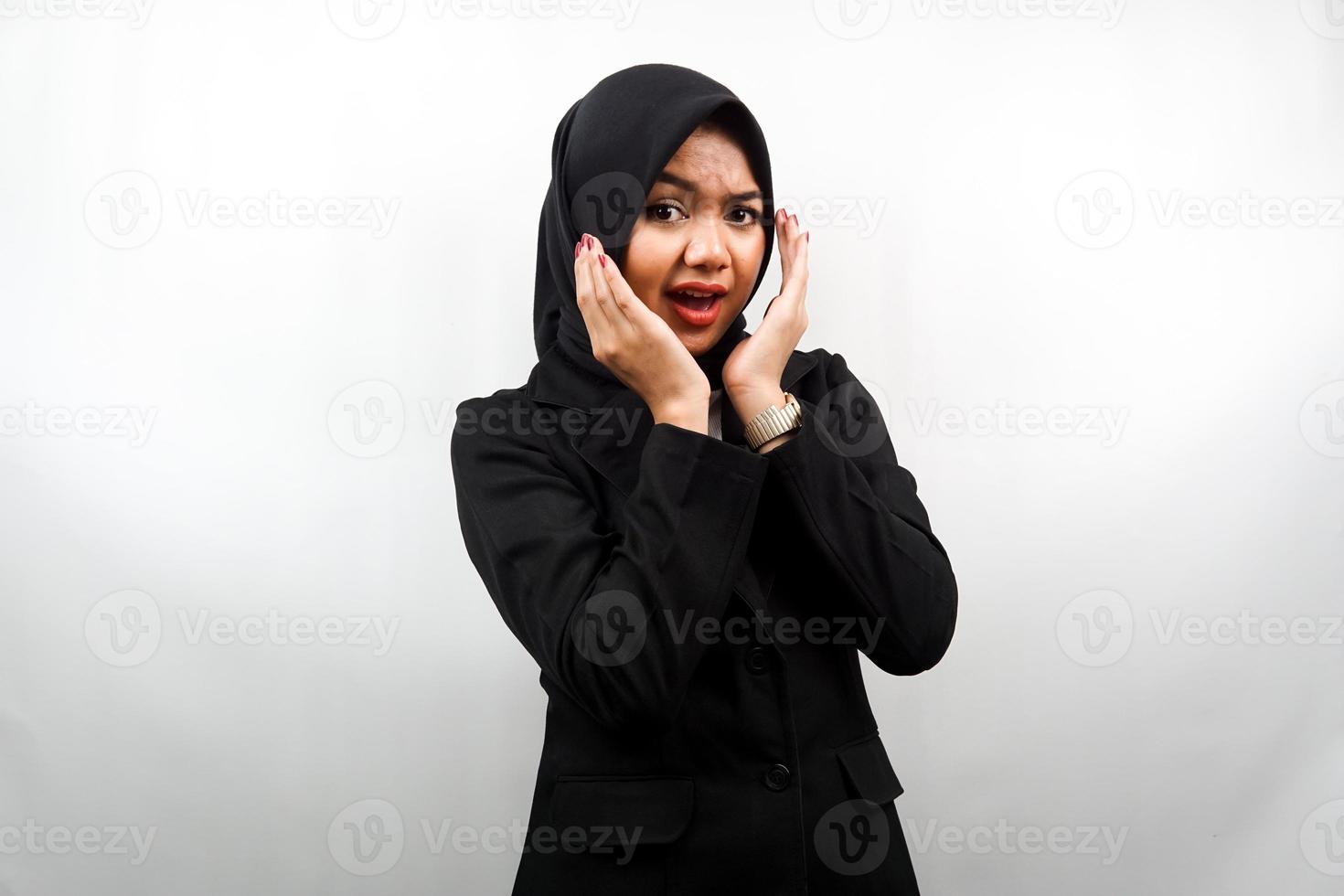 Beautiful young asian muslim business woman shocked, surprised, wow expression, with hand holding cheek facing camera isolated on white background photo