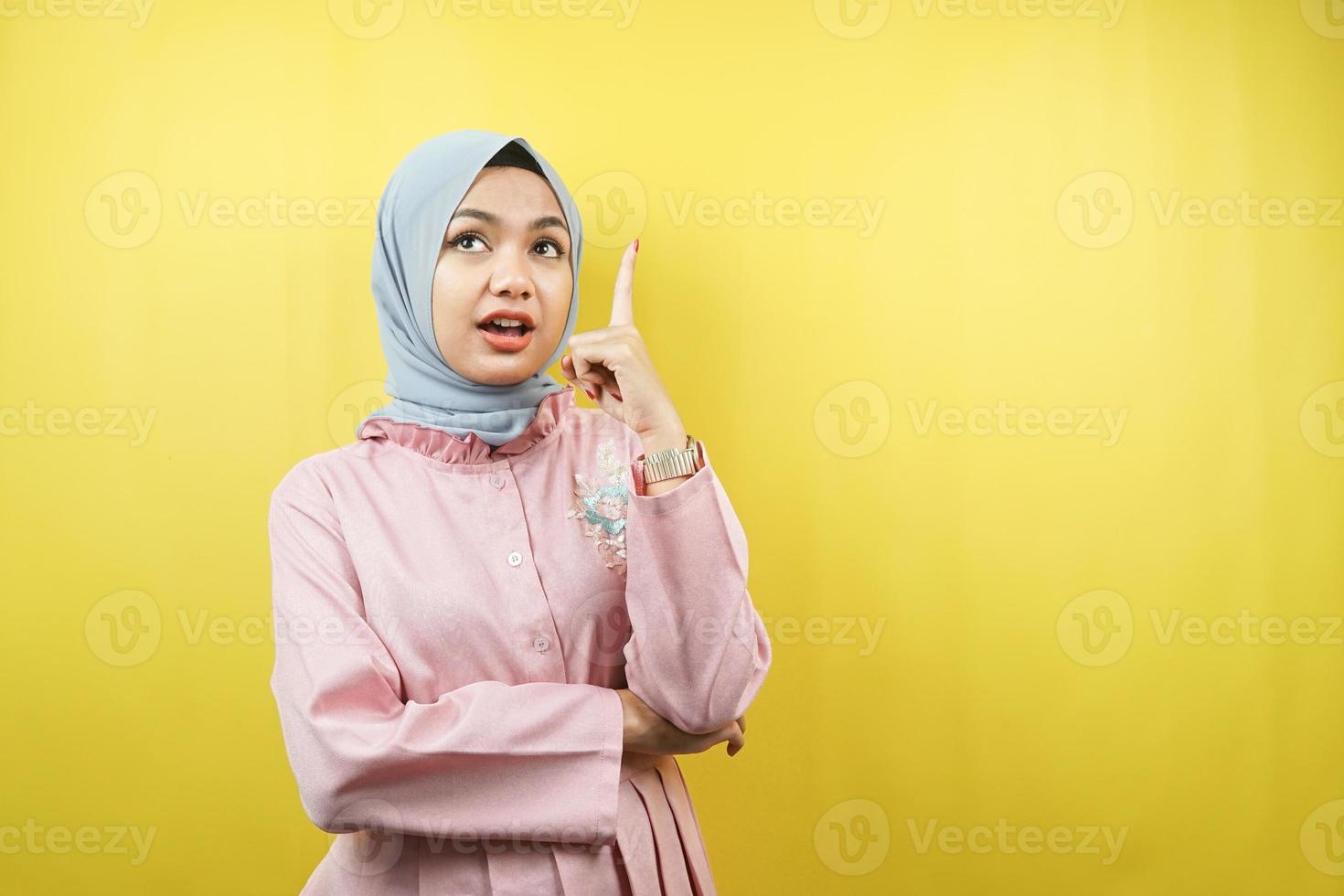 Beautiful young muslim woman getting idea, pointing up, isolated photo