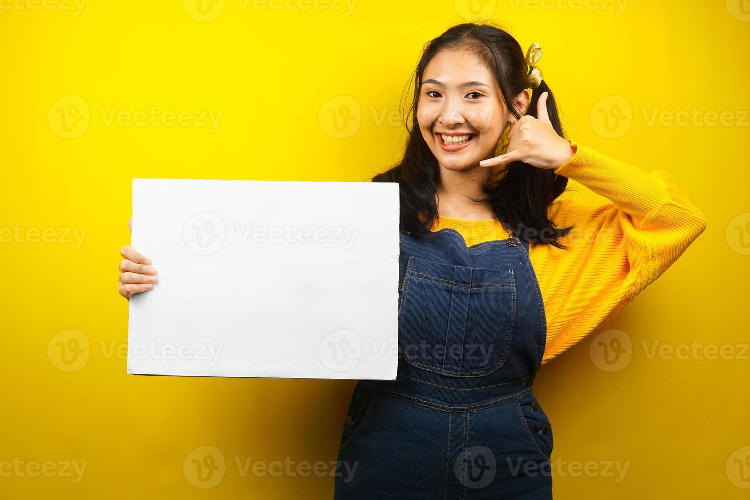 Pretty and cute young woman cheerful holding blank empty banner, placard, white board, blank sign board, white advertisement board, presenting something in copy space, promotion photo