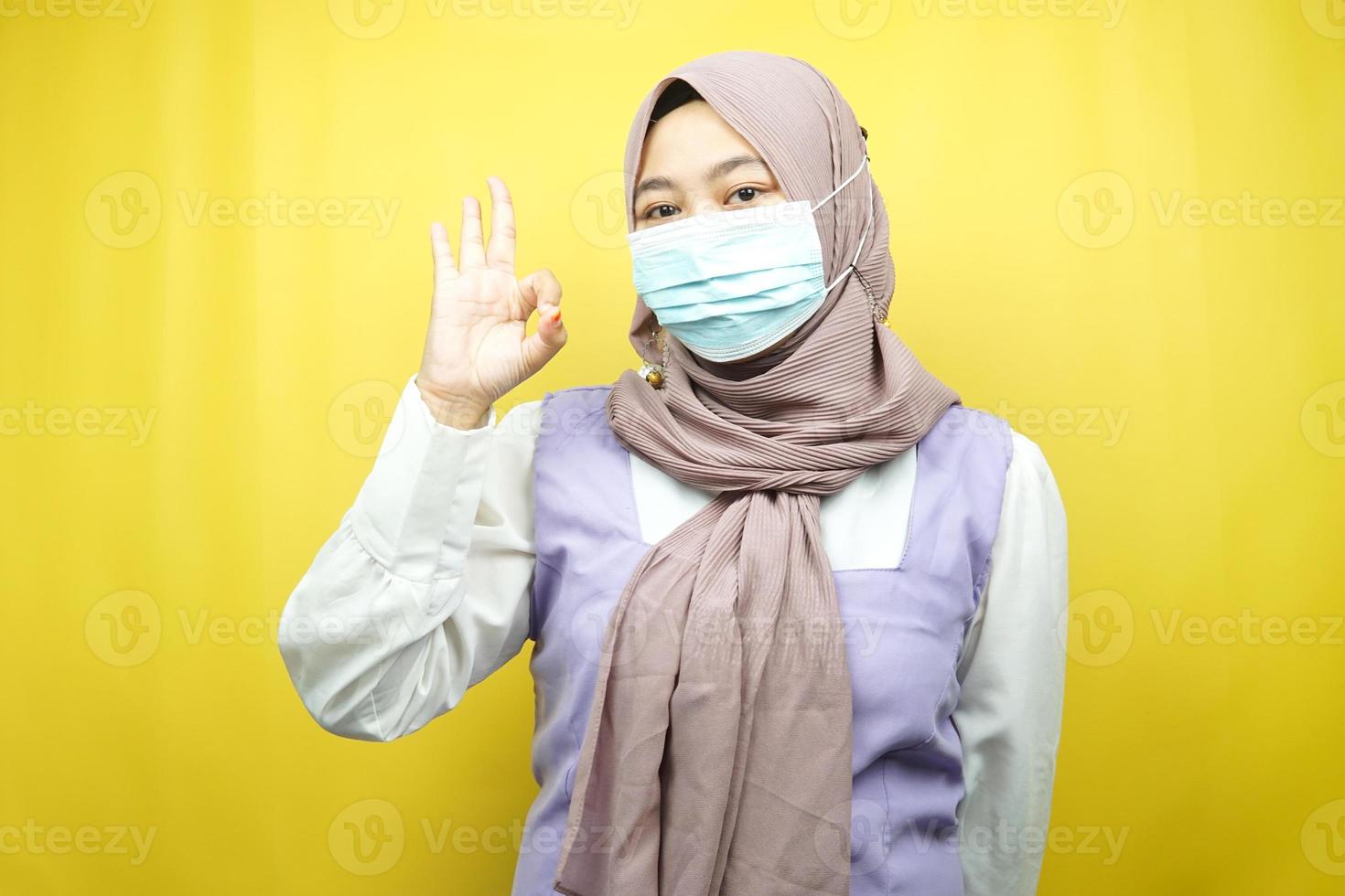 Muslim woman wearing medical masks, anti corona virus movement, anti covid-19 movement, health movement using masks, with hands showing ok sign, good work, success, victory, isolated photo