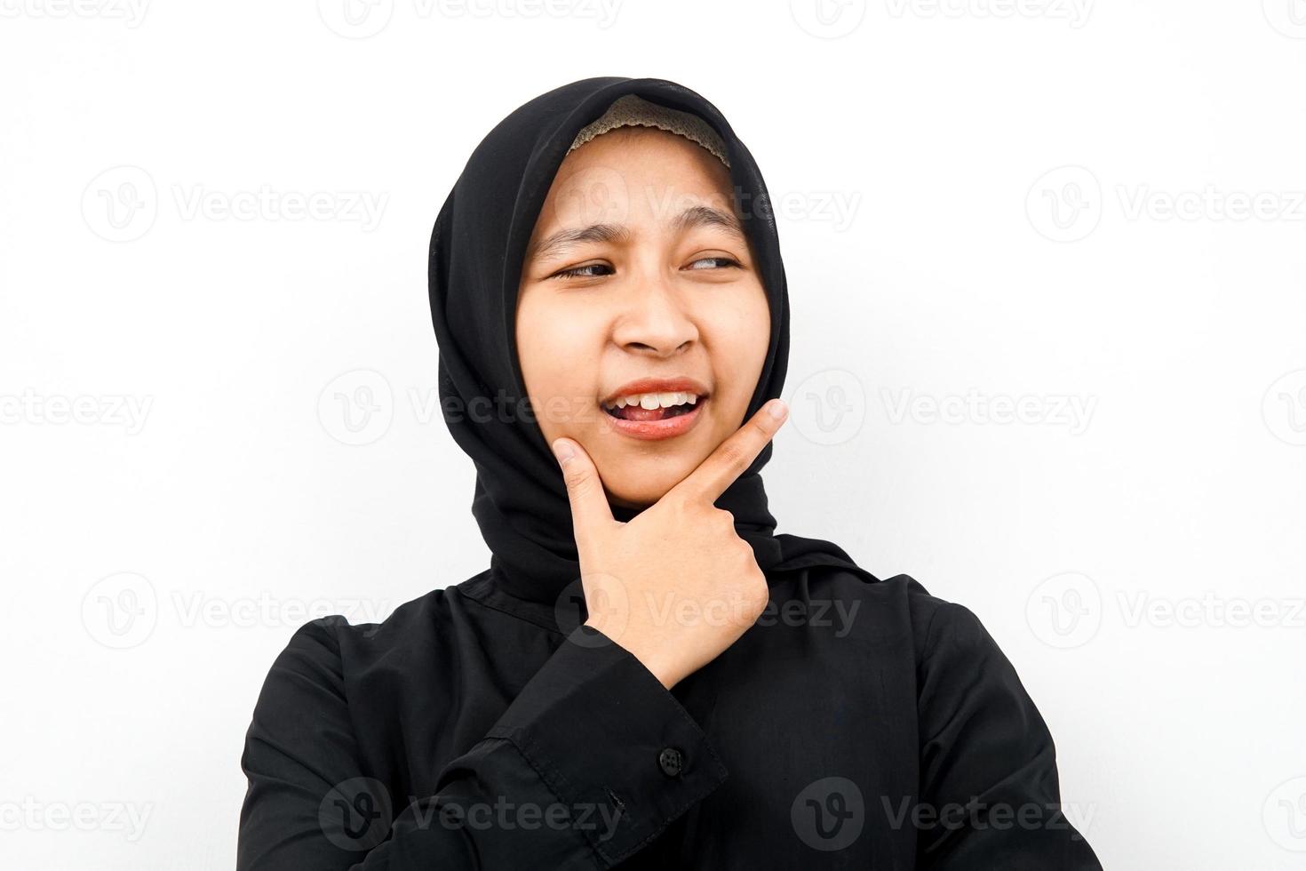 Closeup of beautiful young Muslim woman looking at empty space, presenting something, isolated photo