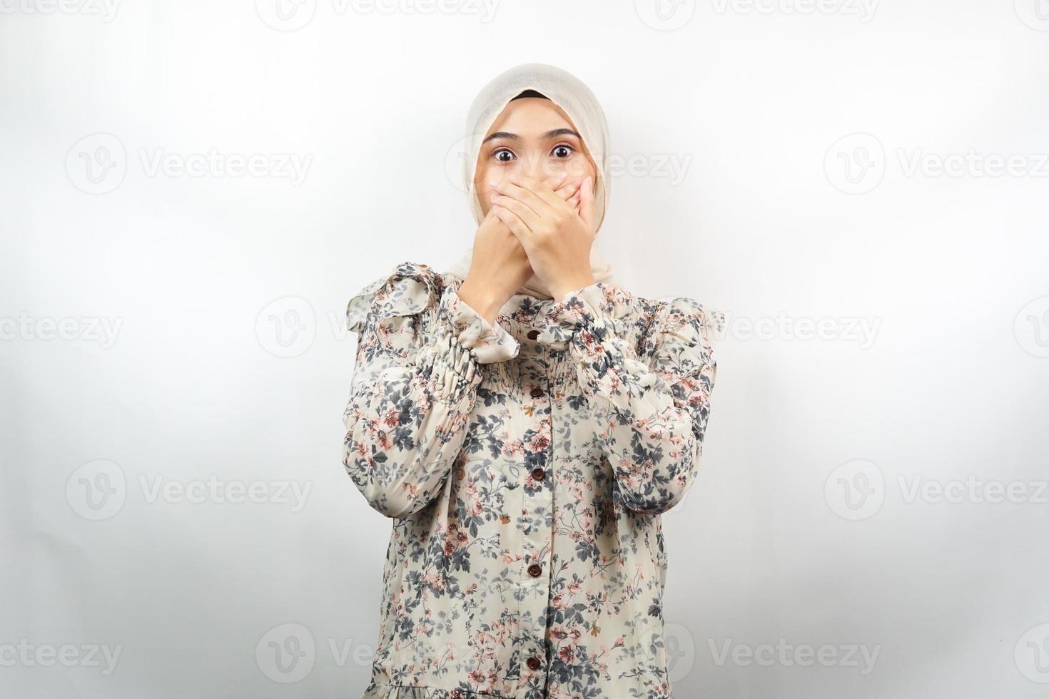 Beautiful young asian muslim woman shocked, surprised, disbelieving, getting shocking information, with hands covering mouth isolated on white background photo