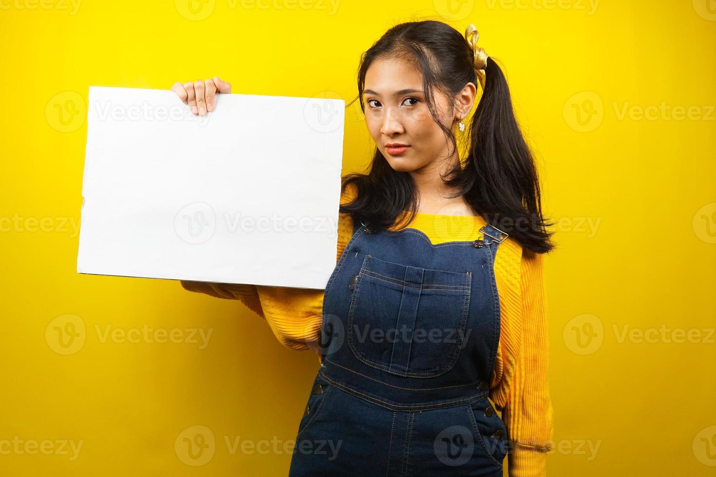 Pretty and cute young woman serious, hand holding blank empty banner, placard, white board, blank sign board, white advertisement board, presenting something in copy space, promotion photo