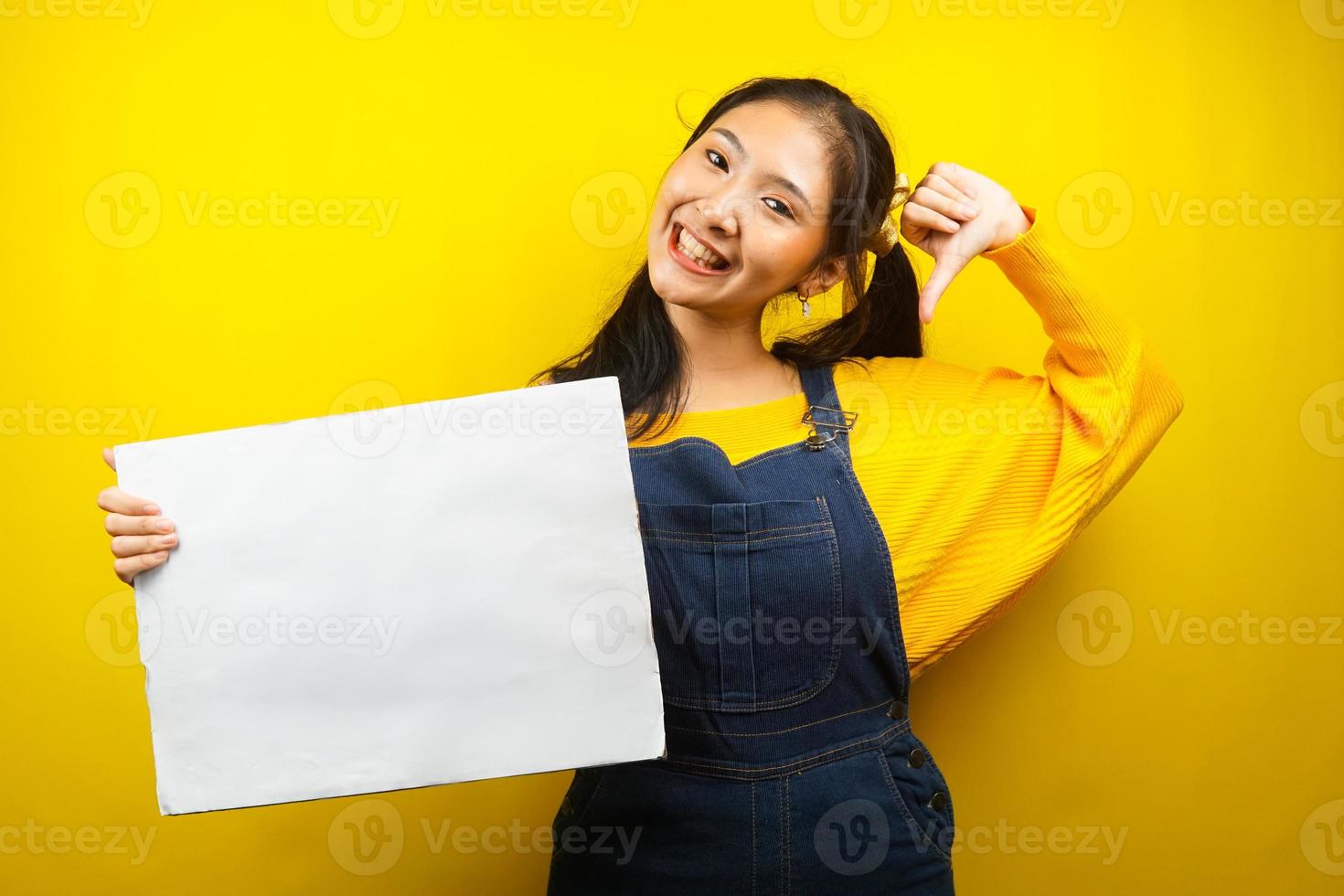 Bonita y linda mujer joven alegre sosteniendo pancarta vacía en blanco, cartel, tablero blanco, tablero de letrero en blanco, tablero de anuncio blanco, presentando algo en el espacio de la copia, promoción foto