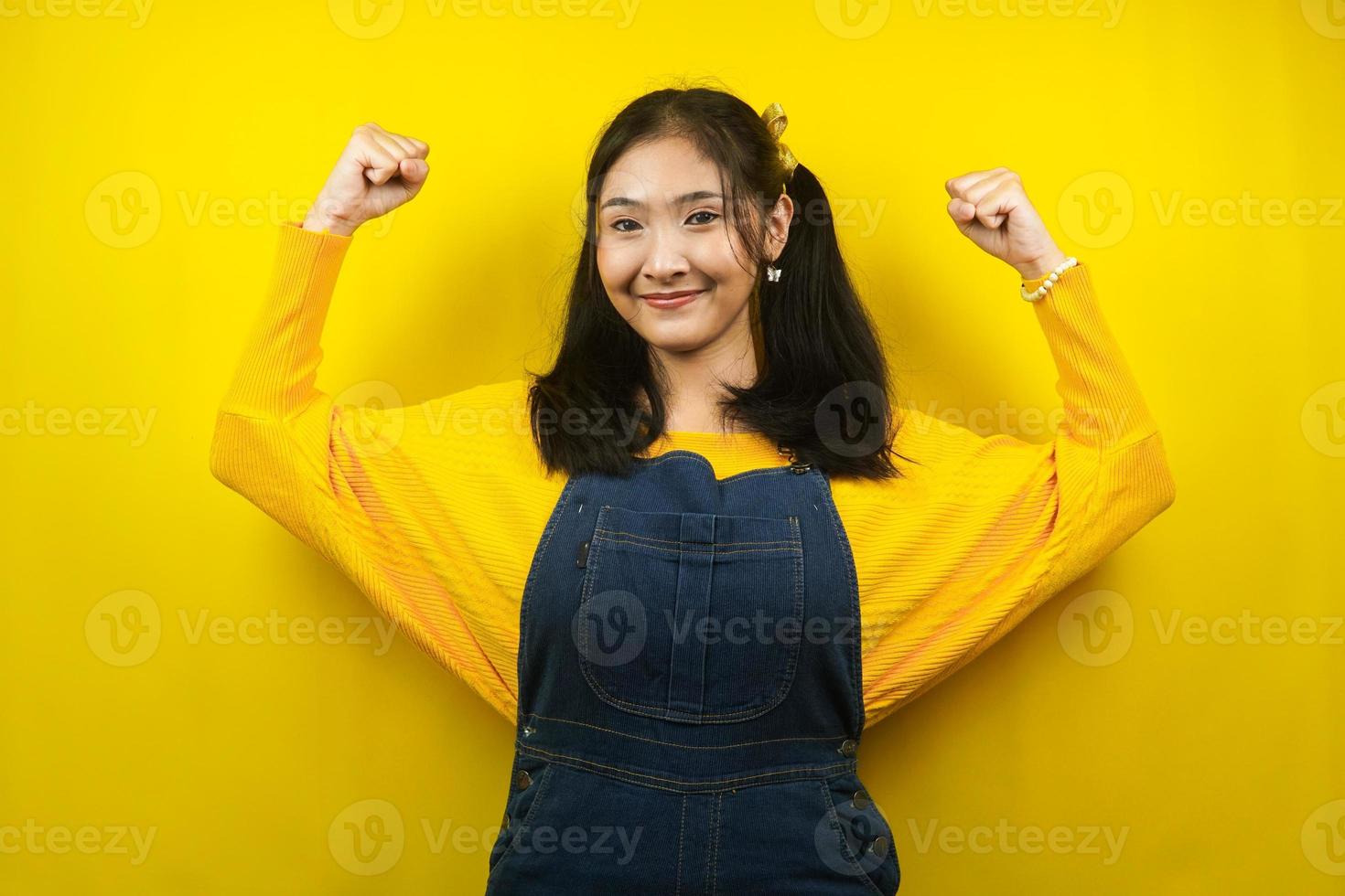 Pretty and cute young woman cheerful, strong, confident, hand clenched strong sign, struggle, achieve success, victory, isolated photo