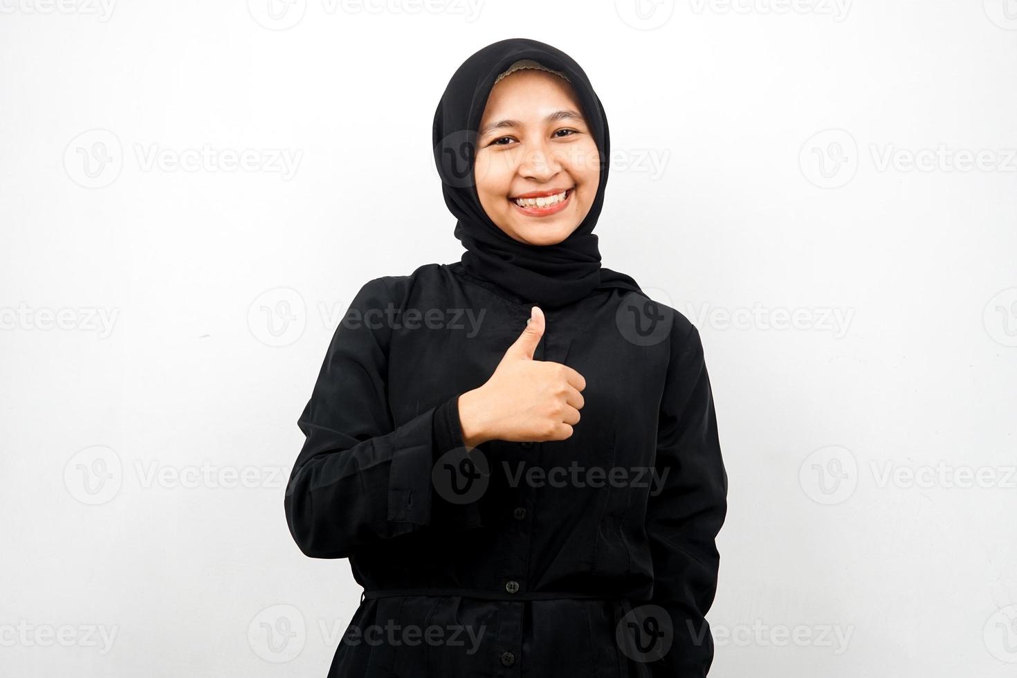 Beautiful young asian muslim woman with thumbs up hand, ok sign, good job, success, congratulations, victory, smiling confident, enthusiastic and cheerful, looking at camera isolated photo