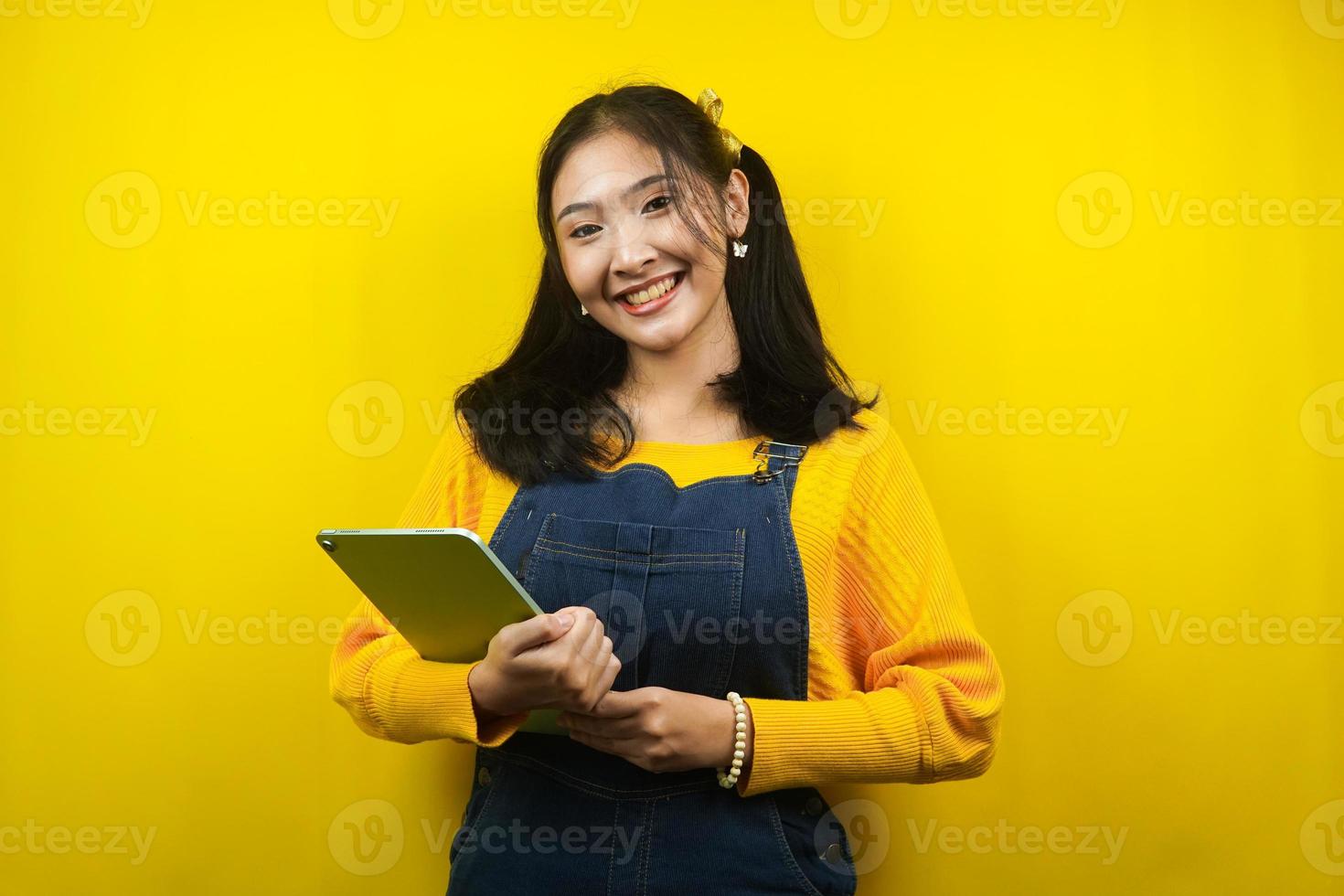 Pretty and cute young woman cheerful, confident, hand holding tablet, presenting something, promoting product, advertisement, isolated photo