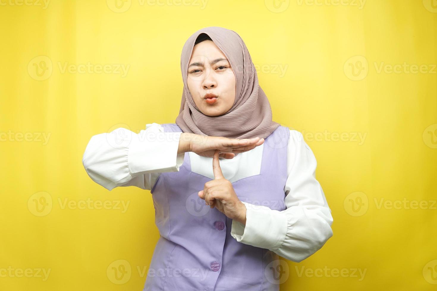 Hermosa joven musulmana asiática con la mano mostrando la señal de pare, la mano de la señal silenciosa, no hable la mano de la señal, no haga ruido la mano de la señal, aislada sobre fondo amarillo foto