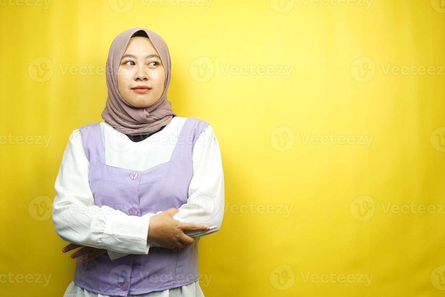 Hermosa joven mujer musulmana asiática haciendo pucheros, sintiéndose insatisfecha, molesta, infeliz, pensando, algo está mal, frente al espacio vacío aislado sobre fondo amarillo foto