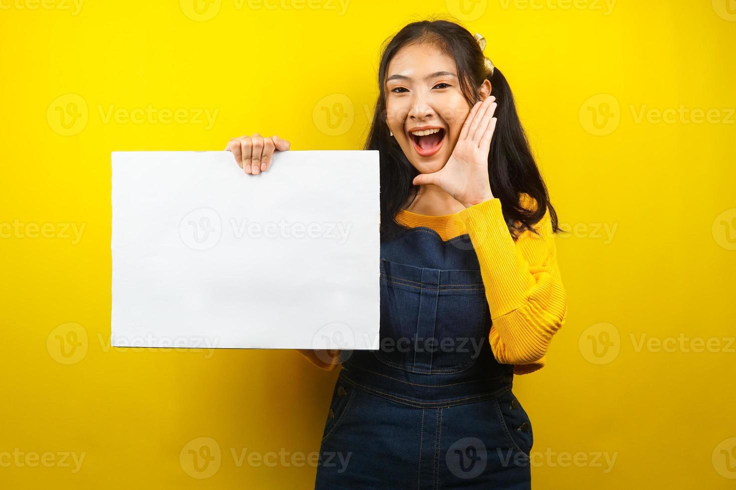 Bonita y linda mujer joven alegre sosteniendo pancarta vacía en blanco, cartel, tablero blanco, tablero de letrero en blanco, tablero de anuncio blanco, presentando algo en el espacio de la copia, promoción foto