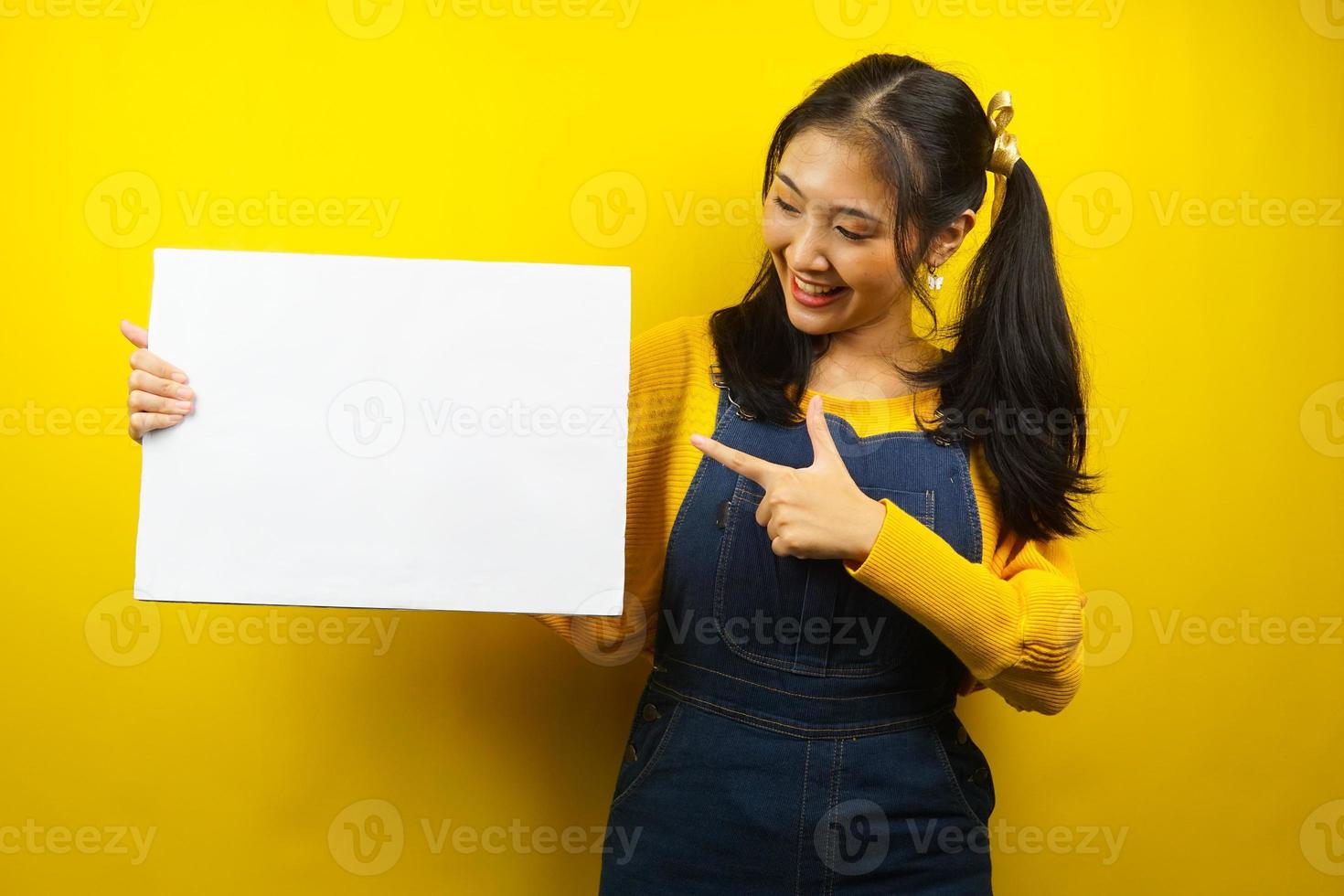 Pretty and cute young woman cheerful holding blank empty banner, placard, white board, blank sign board, white advertisement board, presenting something in copy space, promotion photo